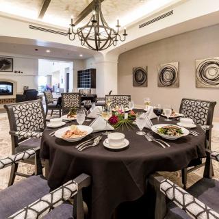 An elegant dining room with a beautifully set table, featuring sophisticated decor and a stylish chandelier.