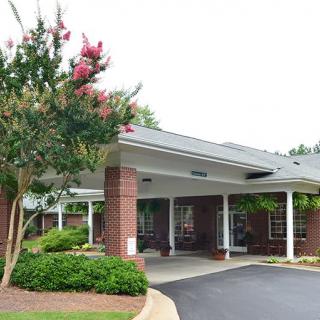 An entrance with a covered walkway surrounded by trees and landscaping.