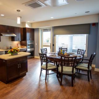 A modern kitchen and dining area with wooden flooring and elegant furniture.