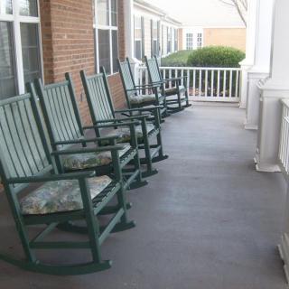 A row of rocking chairs lined up on a porch, perfect for relaxation.