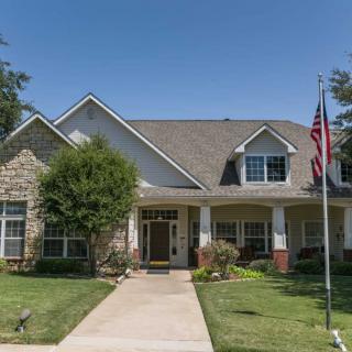 A suburban house with a well-maintained lawn and an American flag.