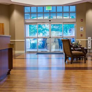 A modern hotel lobby with a reception desk and seating area.