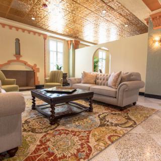 A beautifully decorated living room with a cozy sofa, elegant coffee table, and ornate rug.