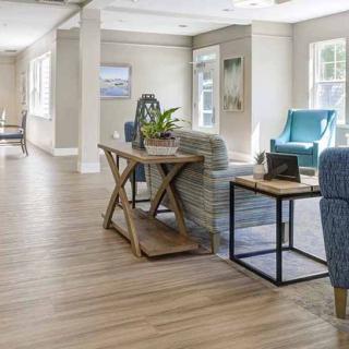 A spacious and well-lit living room featuring modern furniture and wooden flooring.