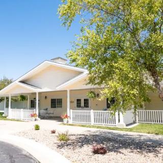 A charming residential house with a spacious porch and surrounding greenery.