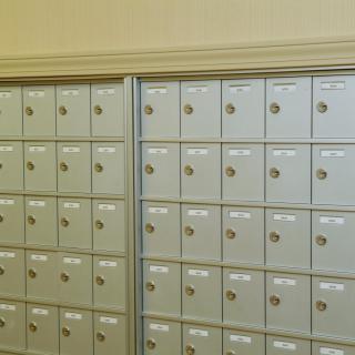 A row of secured mailboxes inside a post office.