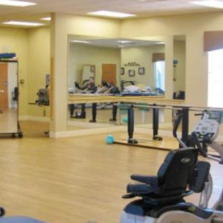 A rehabilitation center's exercise room with mirrors and fitness equipment.