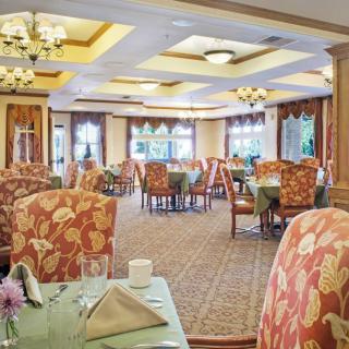 A beautifully decorated dining area with elegantly set tables and floral-patterned chairs.