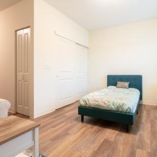 A minimalist bedroom with a single bed and wooden flooring.