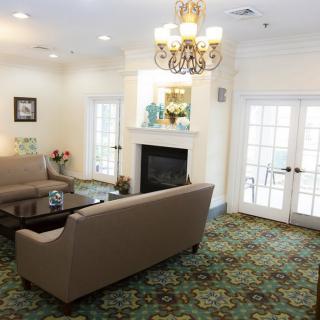 A cozy living room with a chandelier, fireplace, and elegant decor.