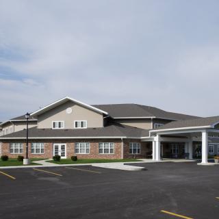 A commercial building with a parking lot visible in front during the daytime.