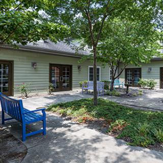 A tranquil garden area with benches and trees outside a building.