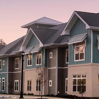 A modern residential building with a unique architectural design at dusk.