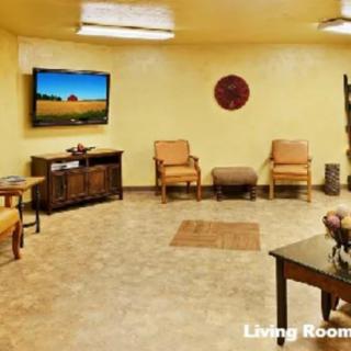 A cozy living room with comfortable seating and a wall-mounted TV.