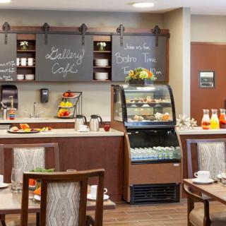 A cozy cafe interior with a breakfast setup including a food display and seating area.