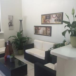 A modern living room with black and white furniture, decorated plants, and wall art.