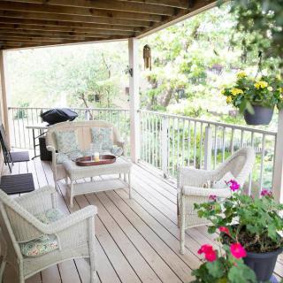 A cozy porch with comfortable seating and vibrant plants, perfect for relaxation.