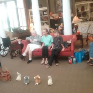 A family gathering in a cozy living room, with children sitting on the couch and engaging in an activity.