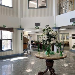 A bright and welcoming lobby with a floral arrangement on a central table.
