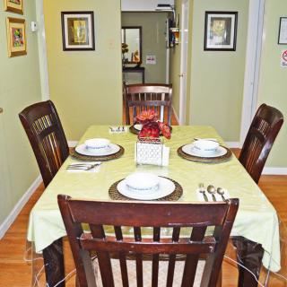 A neatly set dining table with four chairs in a home interior.