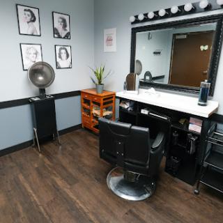 A stylish hair salon styling station featuring a mirror, chair, and decorative elements.