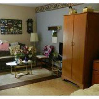 A cozy living room with a sofa, coffee table, and a wooden wardrobe.
