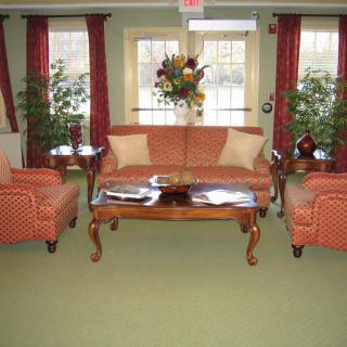 A cozy living room with a classic sofa set, a wooden coffee table, and vibrant decor.