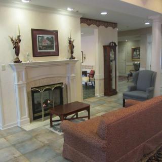 A cozy living room with a fireplace, sofa, and armchairs.