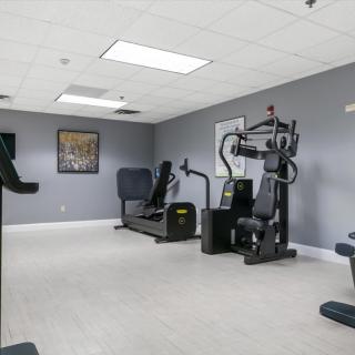 A gym featuring various exercise machines in a clean, well-lit space.