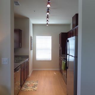 Bright galley kitchen with wooden floors and modern appliances.