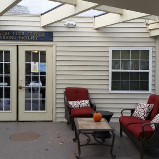 A cozy outdoor seating area with red chairs and a small table, perfect for relaxing.