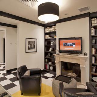 A modern living room with a fireplace, TV, and black and white checkered flooring.