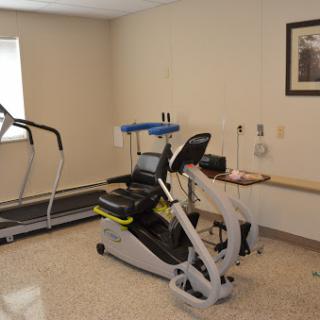 A fitness room featuring a treadmill and an elliptical machine for exercise and rehabilitation.
