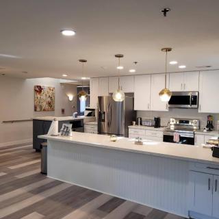 A modern kitchen with an open layout and sleek design, featuring stainless steel appliances and stylish lighting fixtures.