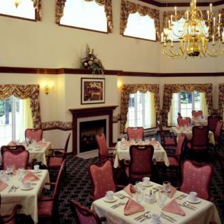 An elegant restaurant dining room with set tables and a chandelier.