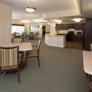 A modern open-concept kitchen and dining area with tables and chairs.