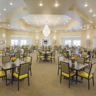A spacious and well-lit dining hall with neatly arranged tables and chairs.
