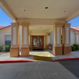 The image shows the entrance of a building with prominent columns and a covered walkway.