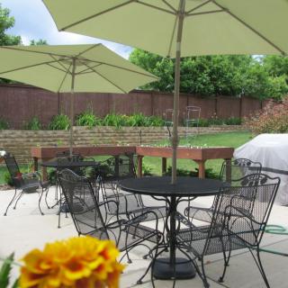 A cozy outdoor patio area with tables and chairs under large umbrellas.