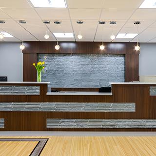 A modern office reception area with wood paneling and contemporary lighting.