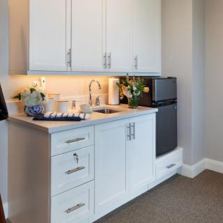 A small modern kitchen with white cabinets and a compact sink area.