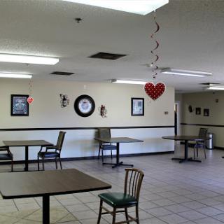 A spacious dining area with tables and chairs, decorated for an occasion.