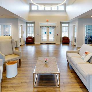 A spacious and modern lobby featuring comfortable seating, wooden flooring, and bright lighting.