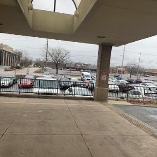 A view of a parking lot filled with cars under a cloudy sky.