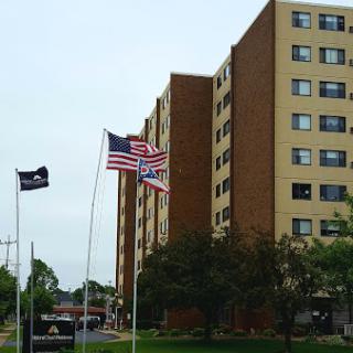A residential building displays the United States flag alongside another flag.