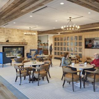A cozy cafe interior with a fireplace, comfortable seating, and warm lighting.