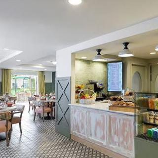 A modern cafe interior with a bakery display and seating area.