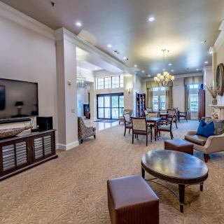 Spacious and elegantly furnished living room with comfortable seating and a large TV.