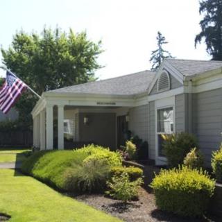 A suburban house with a well-maintained garden and an American flag.
