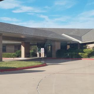 A view of the entrance to a commercial building under a clear blue sky.